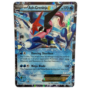 A single Ash-Greninja EX trading card from the Pokémon Basic set, photographed flat against a light neutral background. The card features holographic foil, a blue and red Greninja illustration, and printed game text including 'Dancing Shuriken' and 'Ninja Blade'.