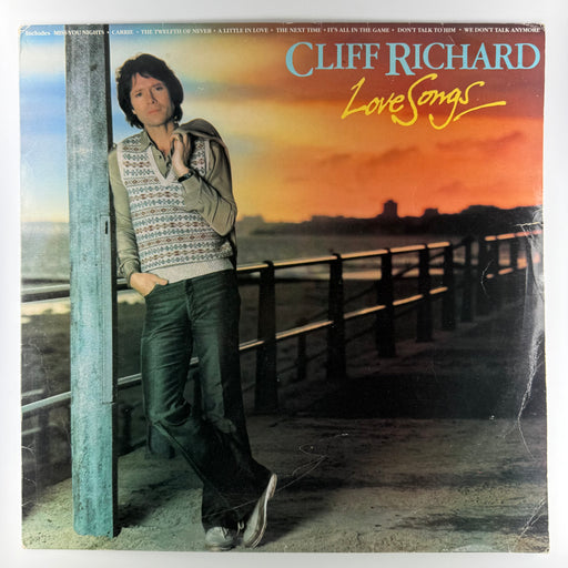 Album cover of 'Love Songs' by Cliff Richard featuring a person leaning against a pole on a beach.