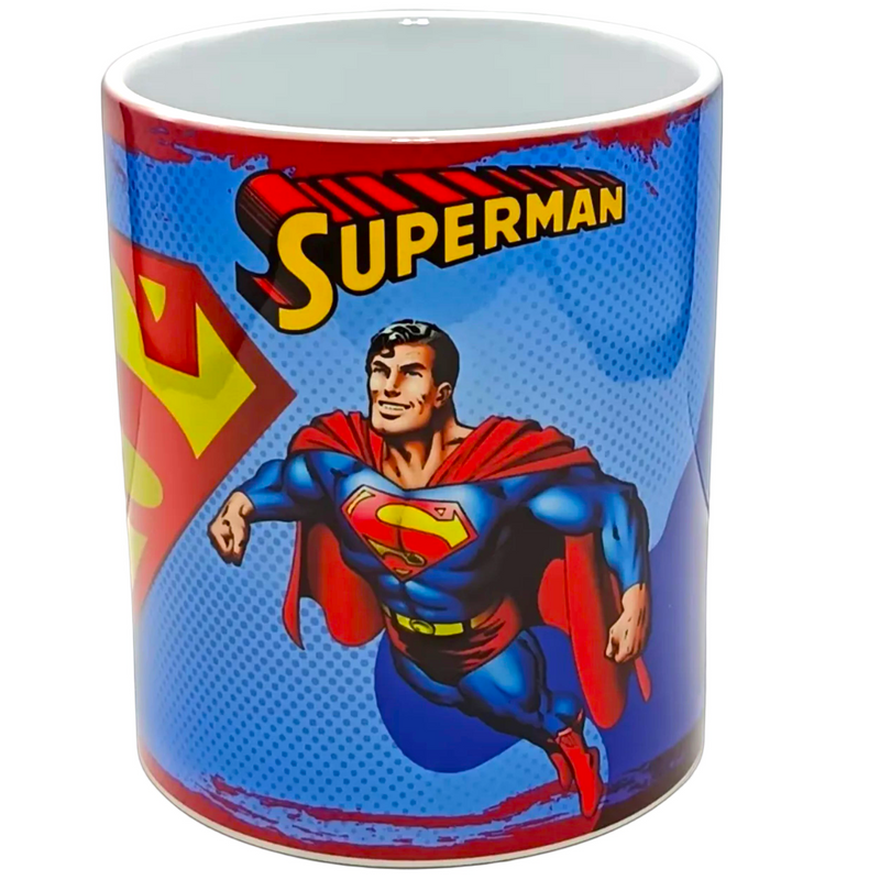 A white ceramic coffee mug featuring a colorful graphic print of Superman on a blue halftone background with the word 'SUPERMAN' in yellow.
