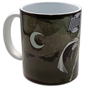A ceramic mug featuring a dark, moody graphic design with a crescent moon and a stylized character, printed in black, gray, and white. The handle and interior of the mug are solid white, set against a plain white background.