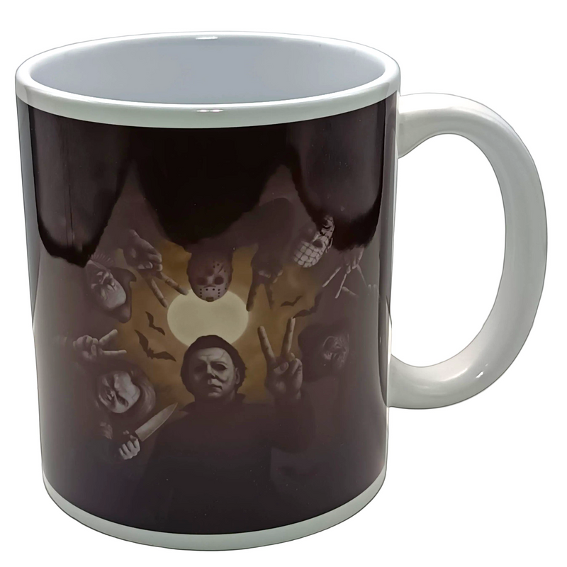 A white ceramic mug with a dark printed graphic on the outside, featuring a circular design with a central white heart and several faces making peace signs. The mug is photographed on a light gray surface against a light gray background.