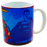 A white ceramic coffee mug featuring a blue and red Superman comic book style graphic print, shown on a light gray background.